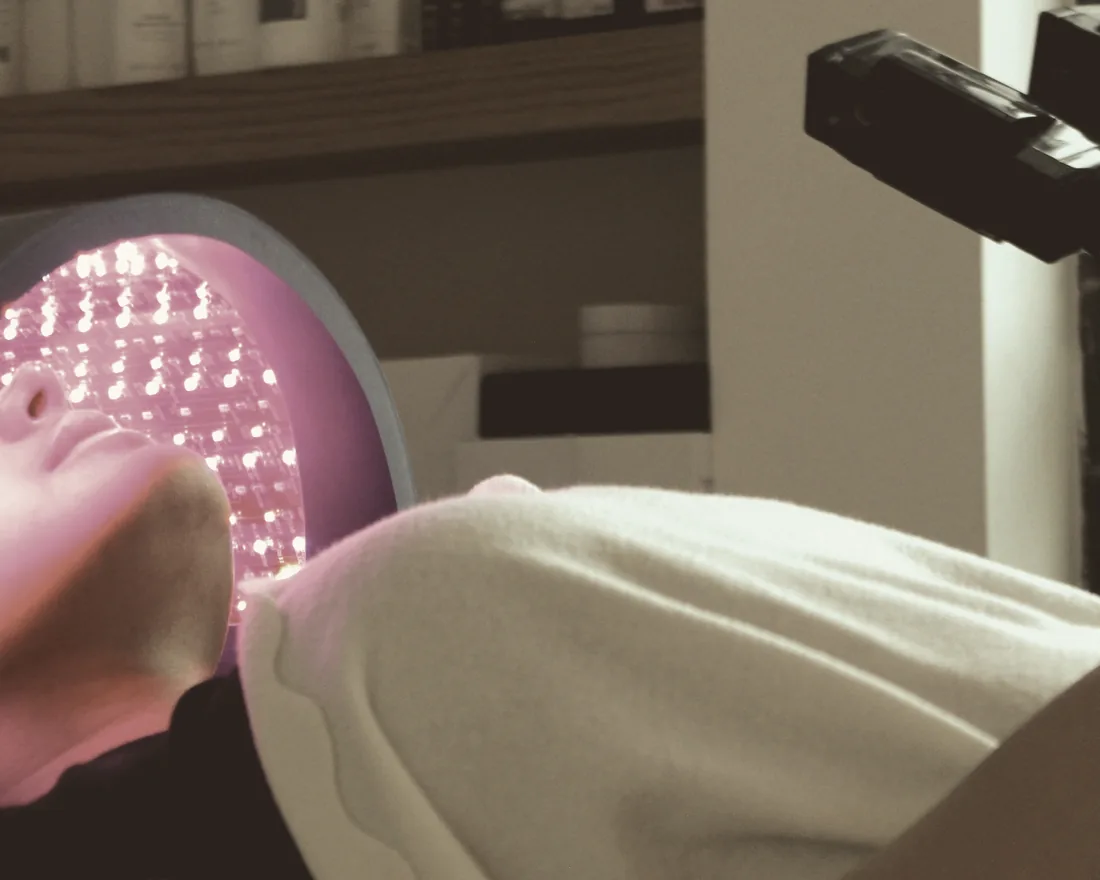 LED-panel över ansiktet under ljusterapi på klinik